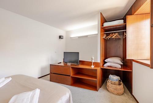 a bedroom with a bed and a tv on a wooden cabinet at Casa à Beira da Água Gerês in Geres