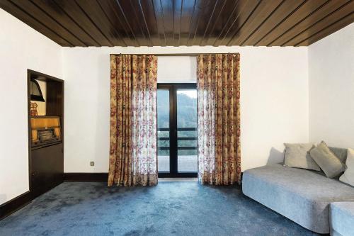 a living room with a couch and a large window at Sonho No Mondego in Penacova