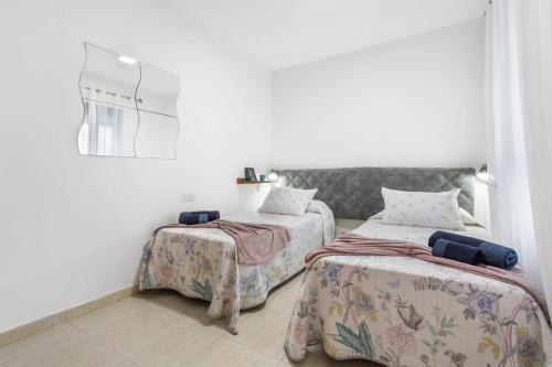 two beds in a room with white walls at Casa Dragos in Costa Teguise