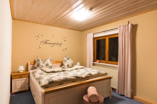 a bedroom with a bed and a window at Ferienhaus Apfelbäumchen Lenzkirch in Lenzkirch