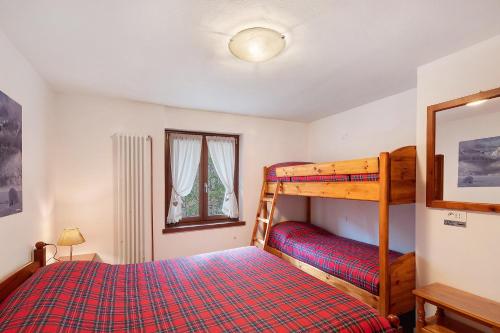 a bedroom with a bunk bed and a window at Ciasa Civetta in Piaia