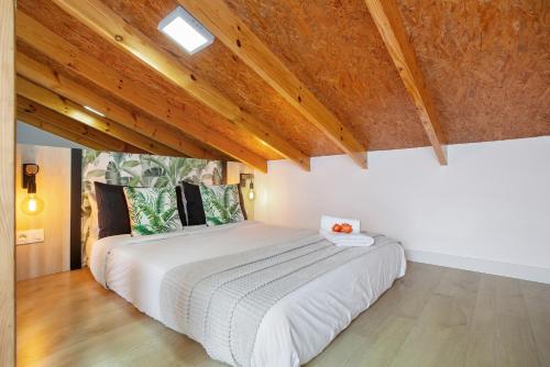 a bedroom with a large white bed with wooden ceilings at Casa Adayeim 1 in Icod de los Vinos