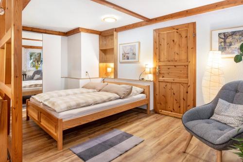 a bedroom with a bed and a chair at Ferienwohnung Am Schleifenbach 2 in Saalfeld