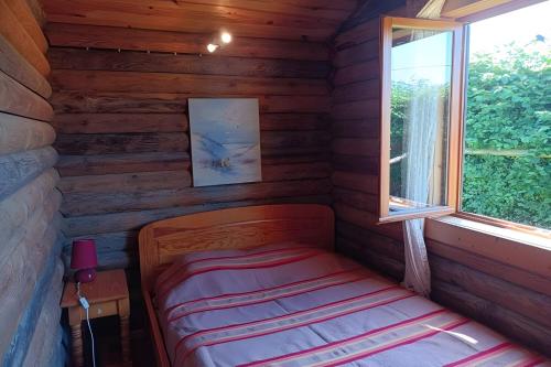 a small room with a bed in a log cabin at Chalet Idéal Randonnée in La Chapelle-Yvon