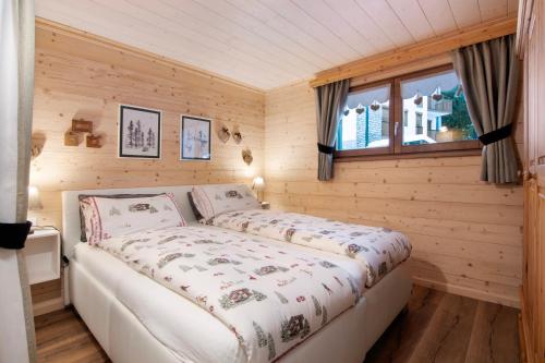 a bedroom with a bed in a wooden room at A casa di Anna in Madesimo