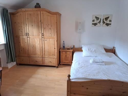 a bedroom with a bed and a wooden cabinet at Algetet Apartment in Hannover