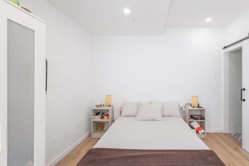 a bedroom with a bed in a white wall at Portblanc Loft in Arenys de Mar