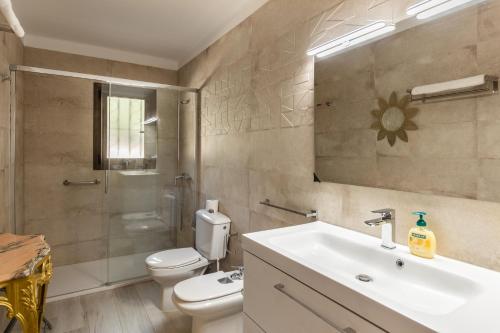 a bathroom with a sink and a toilet and a shower at Finca Can Lluc in Alaró