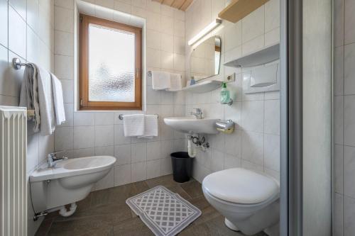 a white bathroom with a toilet and a sink at App Sonne Nr 22 in Lutago