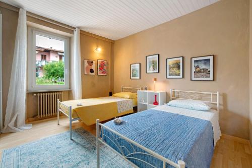 a bedroom with two beds and a window at Isola Bella Apartment in Barghe
