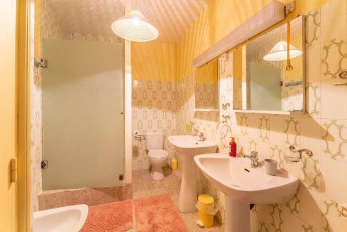 a bathroom with two sinks and a toilet and a mirror at Les Conils in Saint-Pierre-de-Vassols