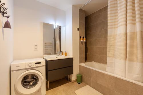 a bathroom with a washing machine and a bath tub at Le Castel in Marseille