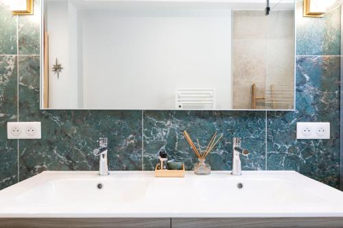 a bathroom with a white sink and a mirror at A Chiusella in Belgodère