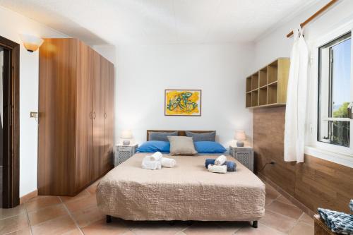 two stuffed animals sitting on a bed in a bedroom at Casa Su Craminu in Dorgali