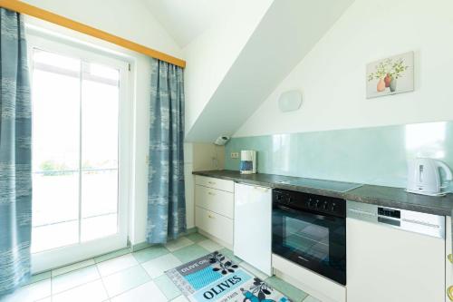 a kitchen with white appliances and a large window at Appartment Isabelle Sky in Lake Pressegg