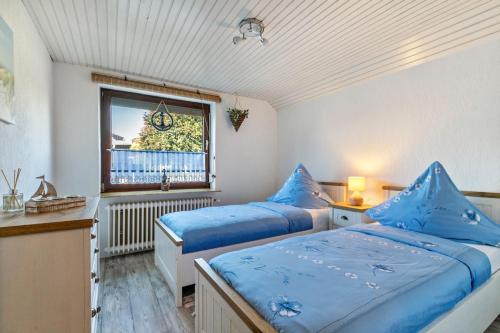 a bedroom with two beds and a window at Dörpshus in Rehm-Flehde-Bargen