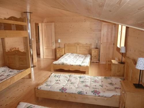 una camera da letto con due letti in una baita di legno di Chalet Bellevue a Les Orres