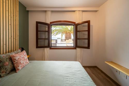 a bedroom with a bed and a window at Callao in Playa Honda