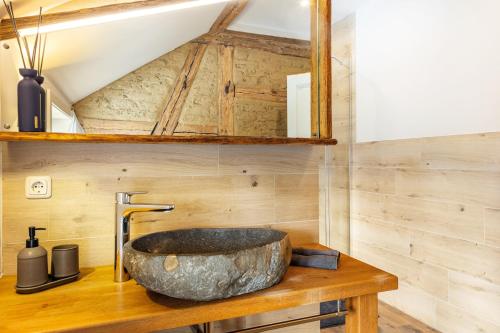 a bathroom with a large rock sink on a wooden counter at Hof Rosenstein in Helle