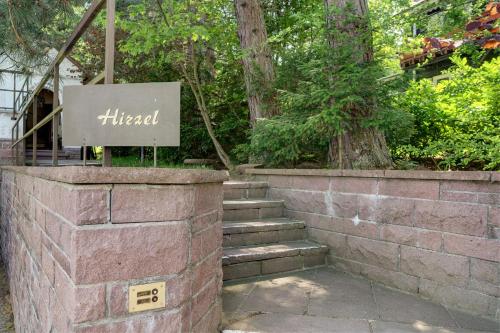 a brick retaining wall with a sign for a hotel at Gästehaus Hirzel in Bad Wildbad
