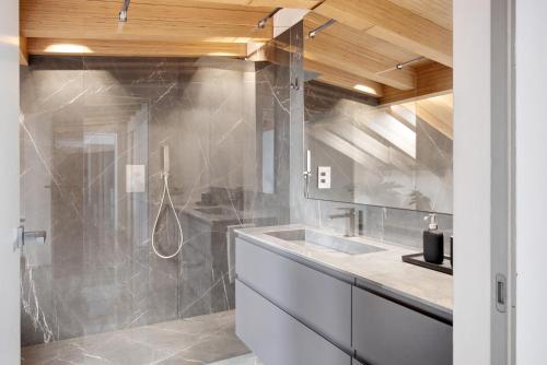 a bathroom with a sink and a shower at Luxury Lakefront Penthouse in Lezzeno