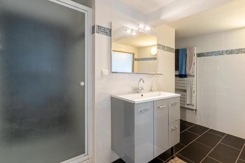 a white bathroom with a sink and a shower at Beau Loft Lorient - centre ville in Lorient