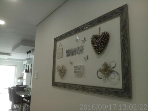 a framed picture of hearts and butterflies on a wall at Marsascala Interlace Apartment with free parking in Marsaskala