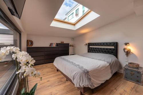 a bedroom with a large bed and a skylight at Beau Loft Lorient - centre ville in Lorient