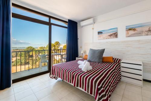 a bedroom with a bed and a large window at Estudio Mirada 309 in Es Pujols
