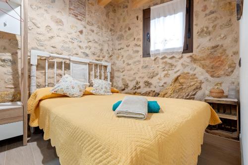 a bedroom with a bed with yellow sheets and a window at Sierra De Majalinos in Ejulve