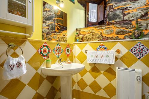 a bathroom with a sink and a mosaic wall at Loureiro in Vega de Logares