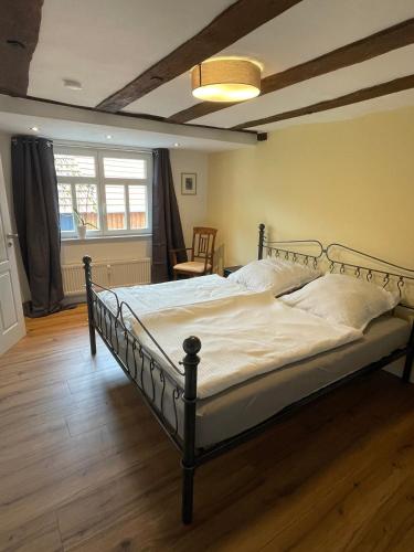 a bedroom with a large bed with white sheets at Thum'scher Hof in Ortenberg