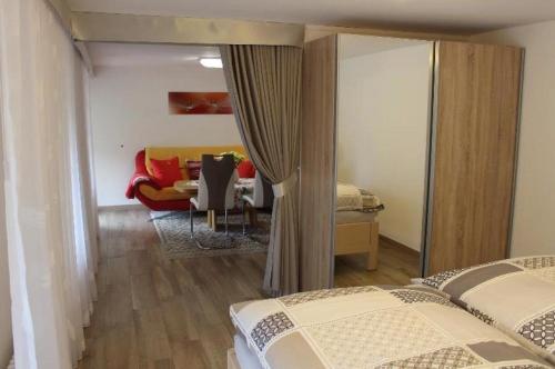 a bedroom with two beds and a living room at Ferienwohnung Landidyll in Enzklösterle