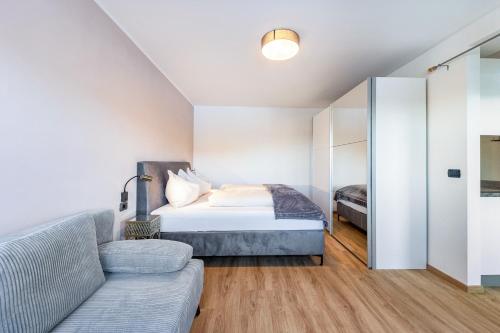 a bedroom with a bed and a couch at Appartement Annie in Nova Ponente