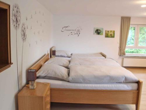 a bedroom with a large bed with white sheets at Ferienunterkunft Schrichten in Schmallenberg