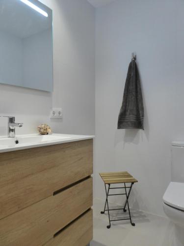 a bathroom with a toilet and a sink and a stool at Angy Apartment in Alcudia