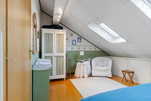 a attic room with a bed and a chair at Appartamento Moser P in Levico Terme