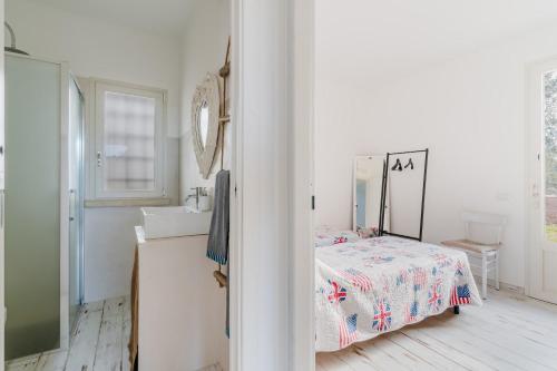 a bedroom with a bed and a sink and a mirror at Dimora Balu' in Parabita