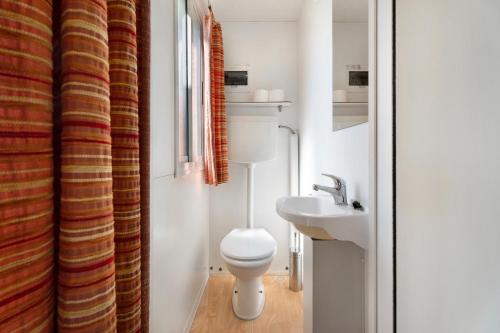 a small bathroom with a toilet and a sink at Camping Royal in Pettenasco