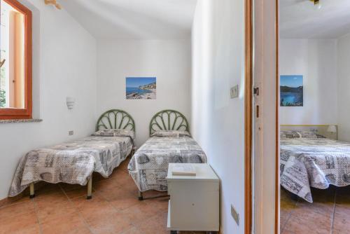 a room with two beds and a table at Appartamenti Bonalaccia in Campo nell'Elba
