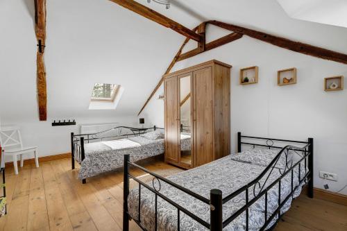 a bedroom with three beds in a room at Le Fenil gîte avec piscine partagée in Saint-Thual