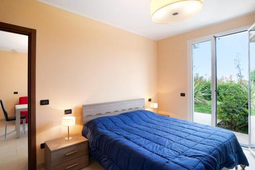 a bedroom with a blue bed and a large window at Appartamento Vallebona in Seborga