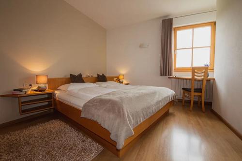 a bedroom with a large bed and a window at Florianshof in Tesimo