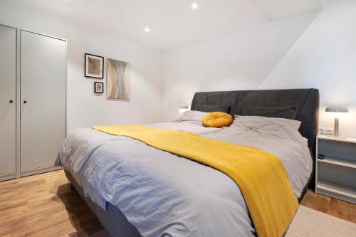 a bedroom with a large bed with a yellow blanket at Eichengeflüster Waldhütte in Wagenfeld