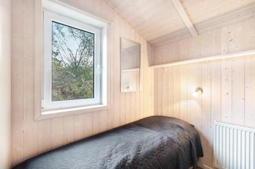 a small bedroom with a bed and a window at Skipper-Lodge Ost in Kosel