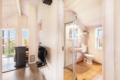 a bathroom with a toilet and a television on a wall at Skipper-Lodge Ost in Kosel