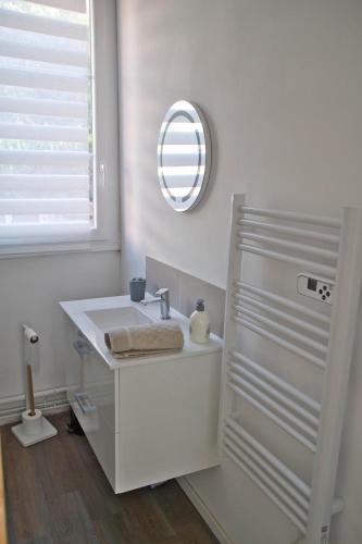 a white bathroom with a sink and a mirror at Cocoon Spacieux Centre Joigny Z2 in Joigny