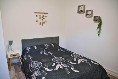 a bedroom with a bed with a black and white comforter at Cocoon Spacieux Centre Joigny Z2 in Joigny