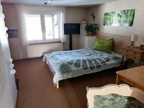 a bedroom with a bed and a table and a window at Ferienwohnung Heustüble in Hinterzarten