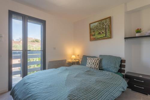 ein Schlafzimmer mit einem Bett und einem großen Fenster in der Unterkunft Villa Igor in Cabasse